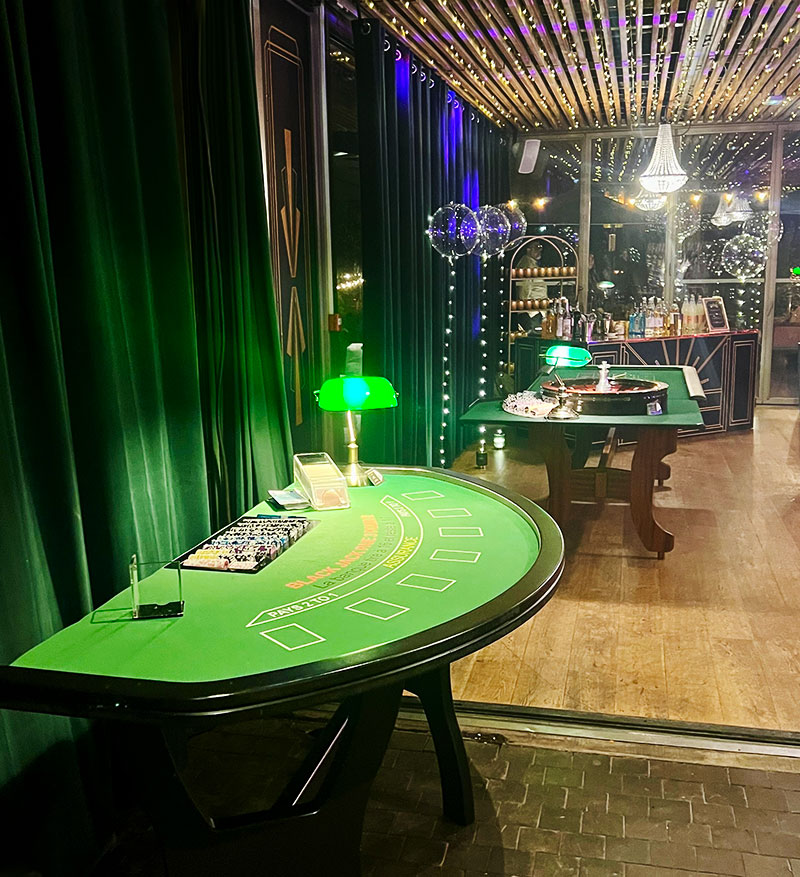 Décoration de salle de réception sur le thème Las Vegas avec tables de jeux et éclairages d'ambiance.